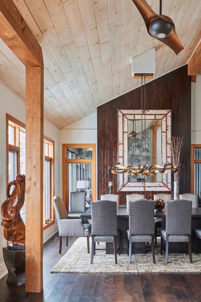 rustic cabin dining room with vaulted wood ceilings, wooden beams and bronze chandelier